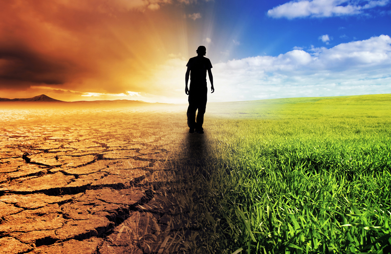 A man walking a road on a sunset horizon